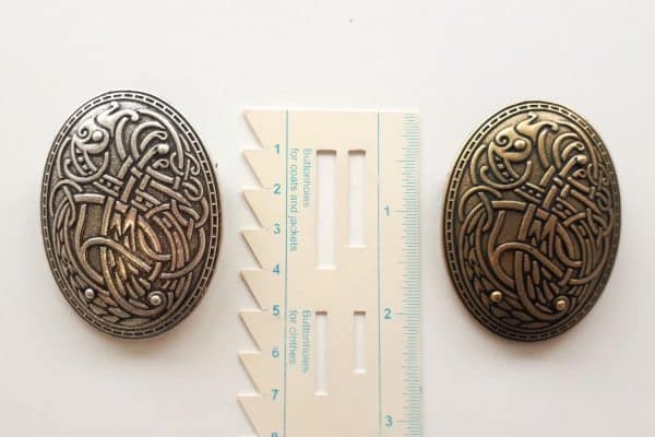 Viking brooches with celtic knot with a ruler for size