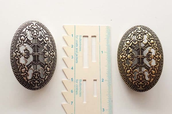 A set of viking brooches with a ruler for size comparison